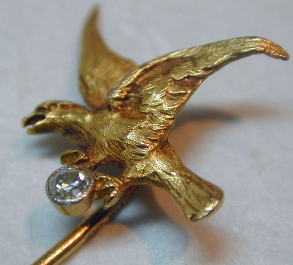 Victorian flying eagle stickpin in 18K yellow gold and set with a diamond. It will highlight a lapel with its dramatic bravura. The eagle is 3/4" wide by 5/8" high. The pin is 3" long.
