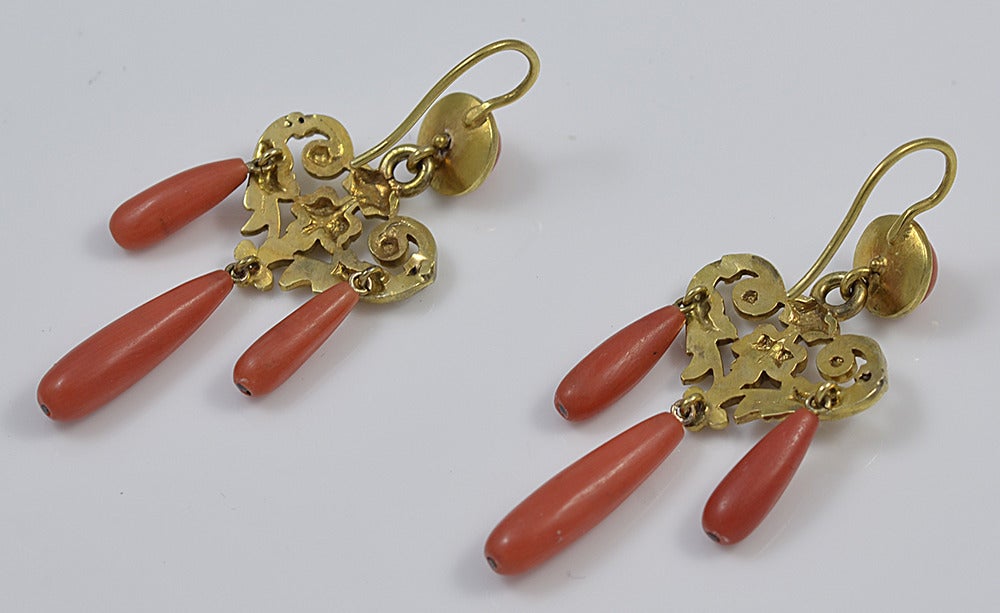 Graceful coral and 15K gold girandole earrings with an elegantly decorated heart shaped central piece. 