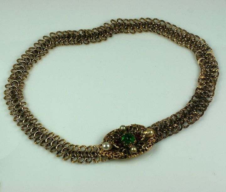 Rich, baroque statement belt by Chanel in pate de verre and faux pearls. Interlocking chain link belt in heavy gilt bronze with a center buckle of gilt filigrees decorated in the Renaissance taste with faux emeralds, rubies and pearls.

Wonderful