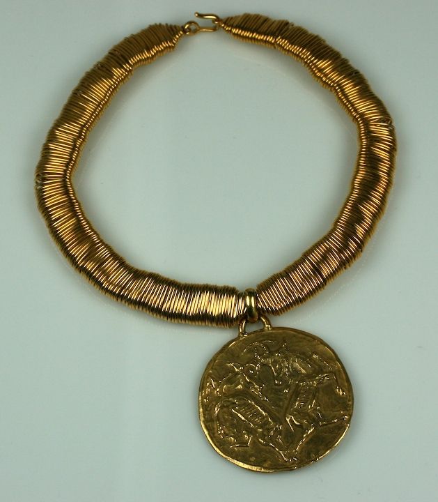 Important collier dans le style zodiacal de Chanel avec un pendentif Capricorne suspendu à un collier en fil de fer élaboré. Le zodiaque figure à nouveau en bonne place dans son lexique de motifs.

Le pendentif est moulé en bronze doré avec un