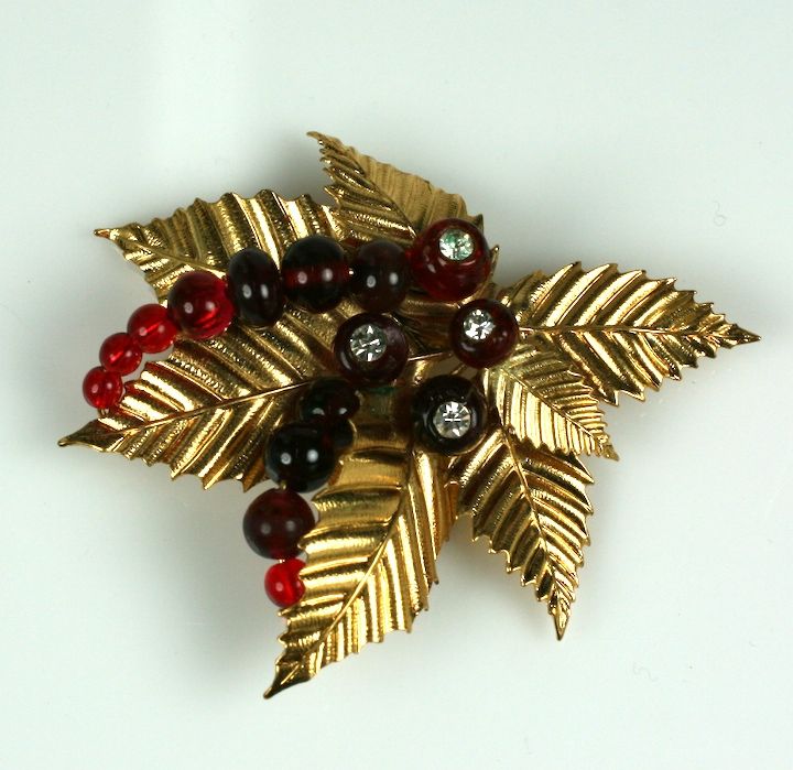 Attractive and unusual holly brooch by Chanel. Robert Goosens is the workshop for this handmade brooch of fluted gilt leaves, pate de verre ruby beads and pastes. Unusual because it does not reference the baroque attitude of many of the jewels found