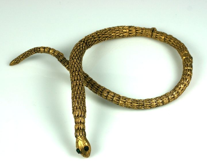 Important gilt snake necklace by Robert Goossens for Chanel. The artistry of this workshop is shown in the manipulation of dozens of gilt filigree caps in descending sizes used to articulate the shape and body of the serpent.

The head is