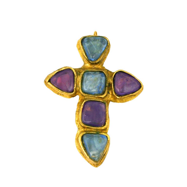 Chanel's appropriation of Medieval, Byzantine and Renaissance forms continued throughout her career, often in the form of oversized cruciform brooches and pendants. 

This one is set in bronze with deep amythest and pale sapphire pate de verre jelly
