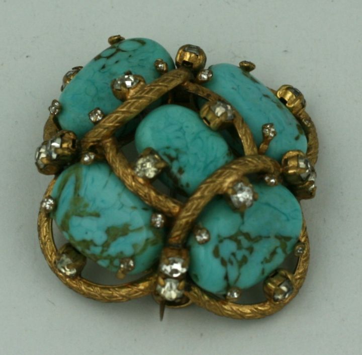 One of Mlle. Chanel's most popular brooch designs.<br />
Handmade Pate de verre beads made to simulate turquoise matrix set in a gilded bronze web scattered with pastes.<br />
Often purchased and worn in pairs,these brooches were frequently seen on