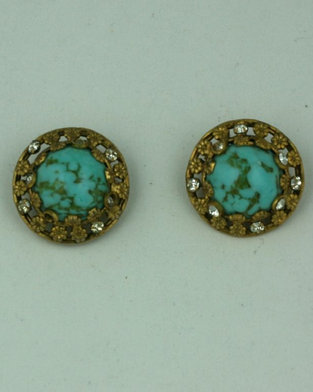 Chanel classic earclips of faux turquoise pate de verre cabochons set in gilt bronze floral filigree, hand set with pastes by studio Goossens. The style of these particular earclips are a staple in the Chanel oeuvre of her post war bijoux fantasie