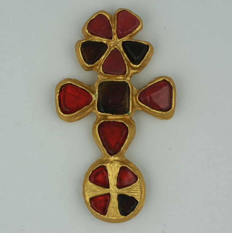 Chanel's appropriation of Byzantine and Renaissance forms continued throughout her career, often in the form of oversized cruciform brooches and pendants.   
This one is set in bronze with deep and pale garnet pate de verre jelly stones, constructed