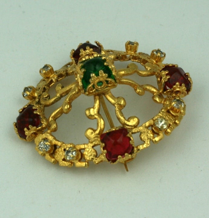 CoCo Chanel Renaissance style oval crest brooch in a modified quatrefoil form with signature cabochon emerald and ruby pate de verre stones and crystals.
This type of brooch was one of Chanel's 