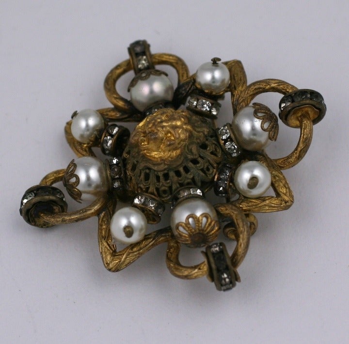 Classic Chanel Lion motif quatrefoil shaped brooch composed of pearls and grey crystal rondelles. All her baroque signatures are evident from the rich gold filigree work, the pearls and lion motifs. Made by Atelier Goossens for Chanel. 1950's