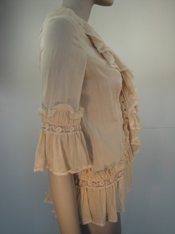 Alexander Mcqueen Spring 2005 cotton ruffled blouse, hidden button front,and cotton lace trim. Size 40

shoulder to shoulder 15 inch
bust 35 inch
waist 32 inch