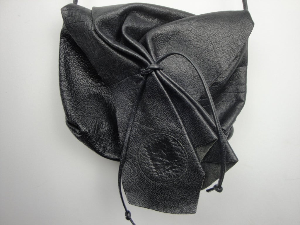Carlos Falchi black leather cinched handbag with one zipped interior pocket.