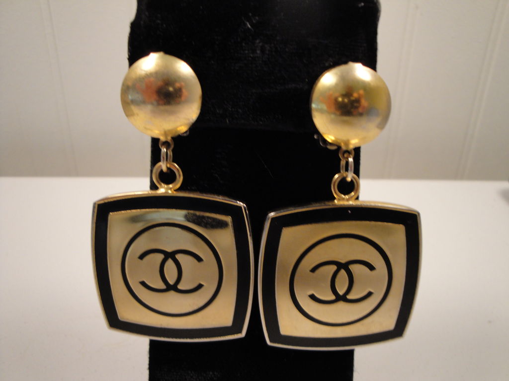 Chanel logo, black enamel and gilt earrings with clip backs.