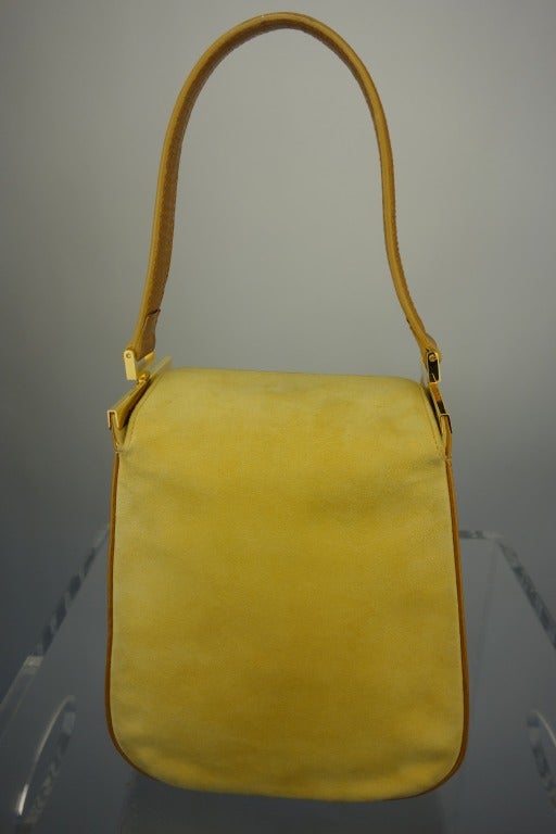 Escada mustard colored suede bucket bag with gold embossed leather trim, snap top, and one interior pocket.