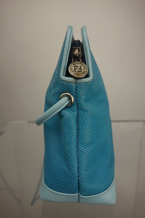 Fendi turquoise perforated leather bag with long shoulder strap, one interior zip pocket, and fully lined.