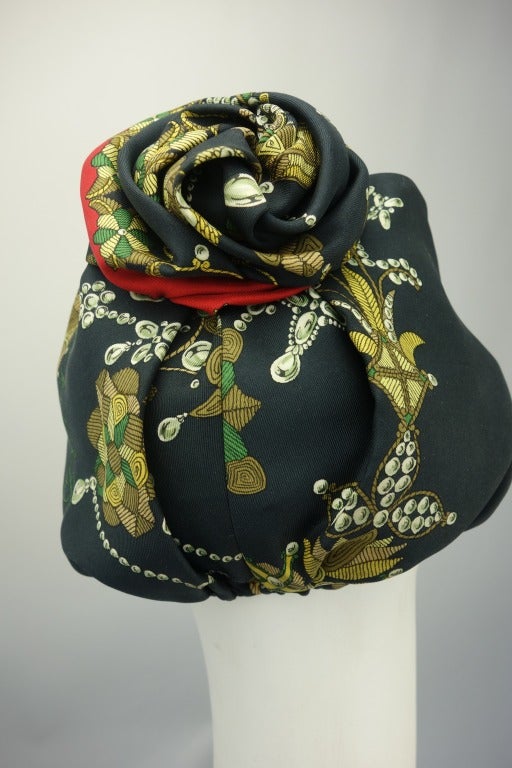 Hermes black printed silk turban with net lining. 

Circumference: 21.5