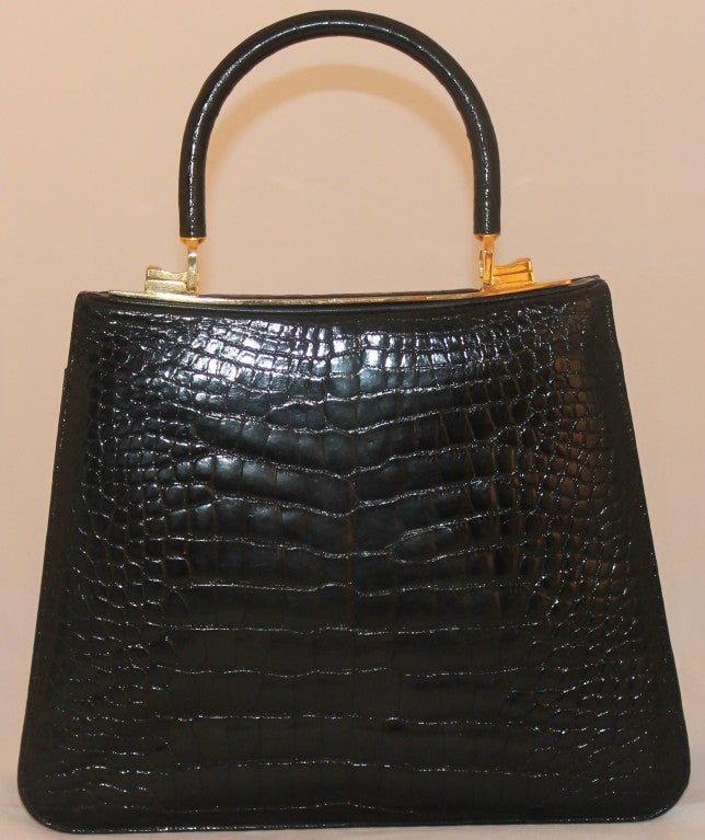 Judith Leiber Black Alligator Kelly Handbag w/ GHW. Detachable top handle, comes with attachable shoulder strap and coin purse. Flap closure and 2 interior pockets. Handle drop 3.5