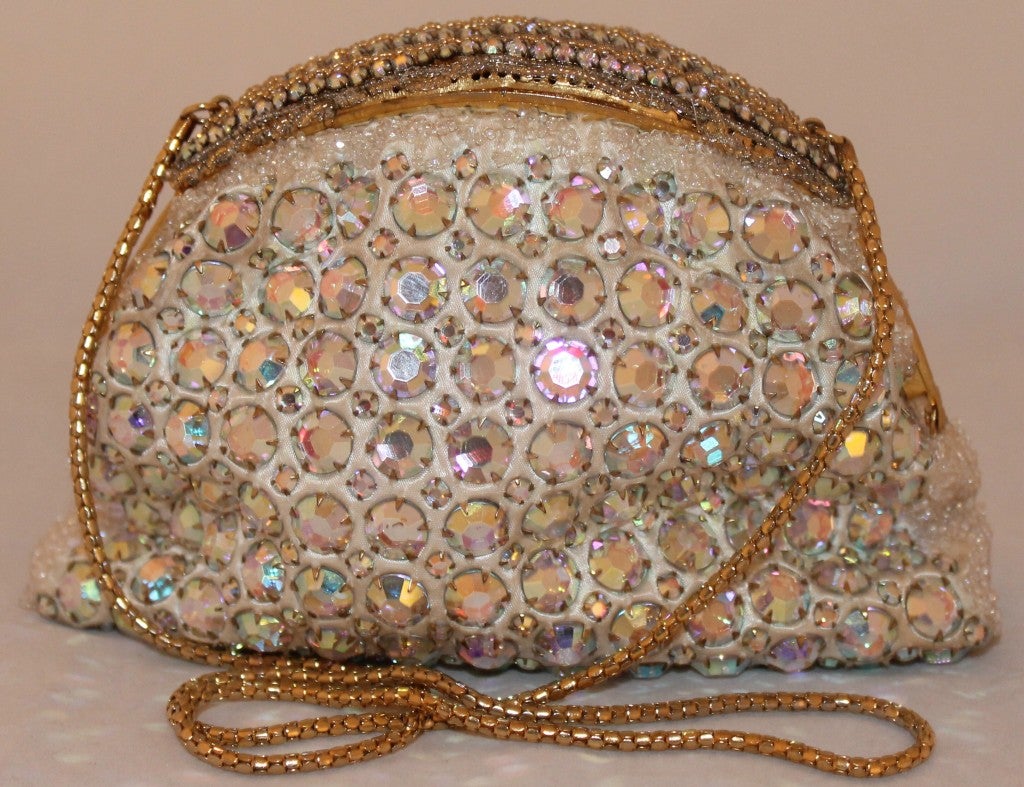 Gold and heavily beaded clutch with gold tone chain. Satin lining. Beautiful detail. Snap closure chain drop is 14.5 inches.
