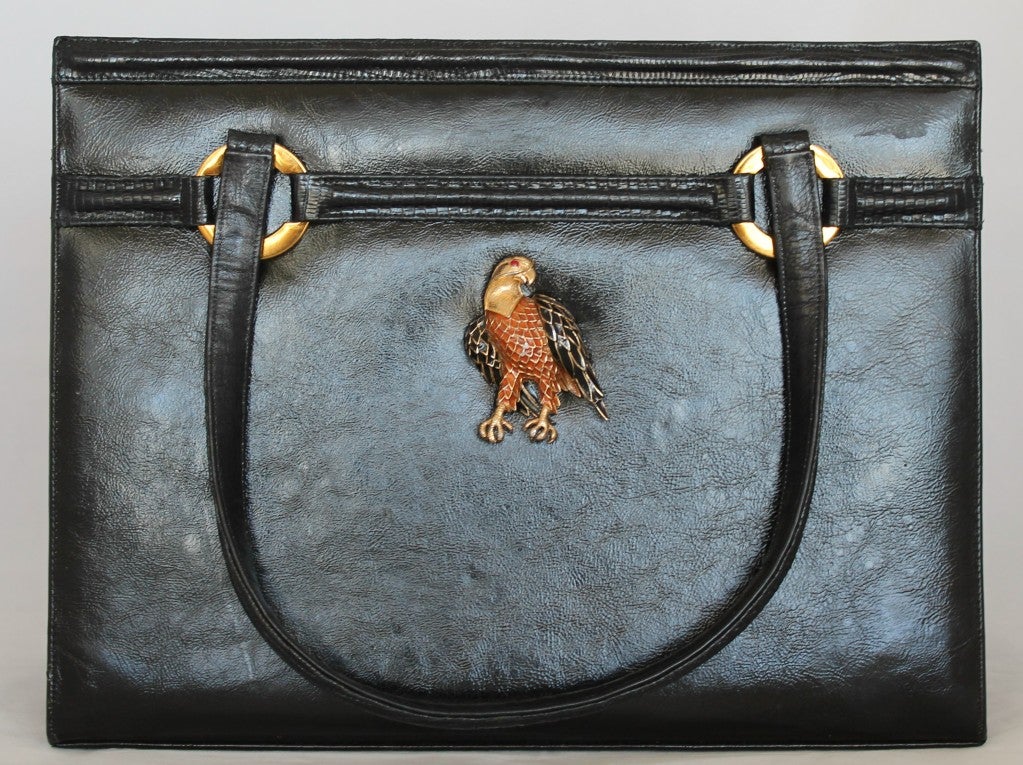 Vintage Martin van Schaak black leather handbag with beautiful eagle brooch on front of bag. Double handles. Snap iinterior closure with two open compartments. Two zip pockets in the interior. Leather liner. Gold hardware. Handle drop is 6.5 inches.