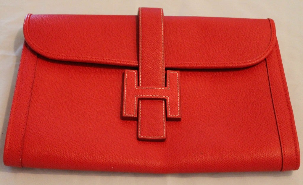 Hermes red leather clutch, H flap closure. One interior zip pocket.