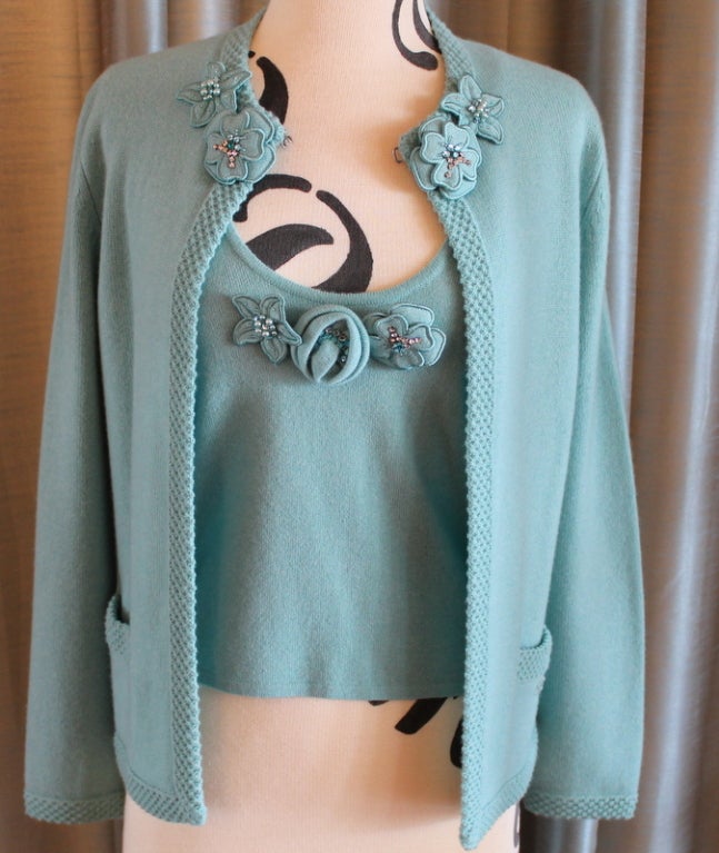 Chanel Turquoise Cashmere Cardigan Set with Detachable Flowers - 40 - 05P. Closure at top for sweater. Scoop neck shell. Sleeveless shell. Two pockets on sweater. 

Measurements:
Sleeve length 22.5. 
Shell measurements: 
length 20 inches.