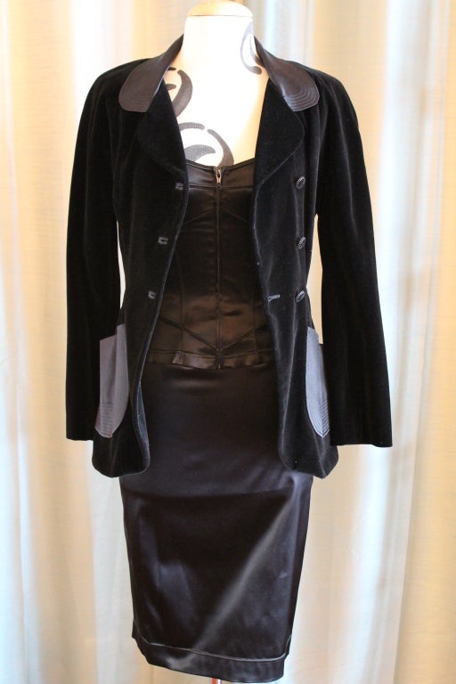 Lagerfeld 3 piece black, nylon/spandex and cotton/rayon, jacket, top, skirt. Jacket has 4 front pockets, vent button back with tie for adjustment. This 1990's Karl Lagerfeld creation has a Sleeveless bustier, zip front top and Pencil skirt. 
Jacket
