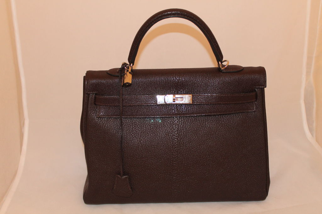 Hermes Chocolate Brown Togo Leather Kelly Bag-35cm with detachable strap and Silver hardware. This item is in Excellent pre-owned condition. Comes with duster, rainpouch and box.