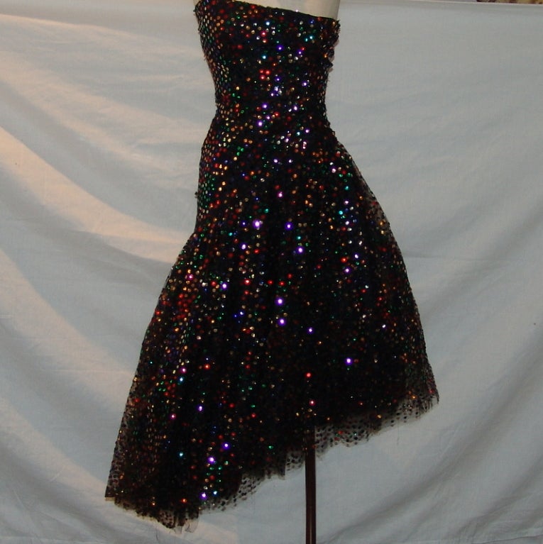 Scaasi vintage black tulle dress with multi colored sequin and a removable bow.  
Size 4 - Circa 80's
Measurements:
Length 35" on one side the other side 45", bust 32", waist 28"