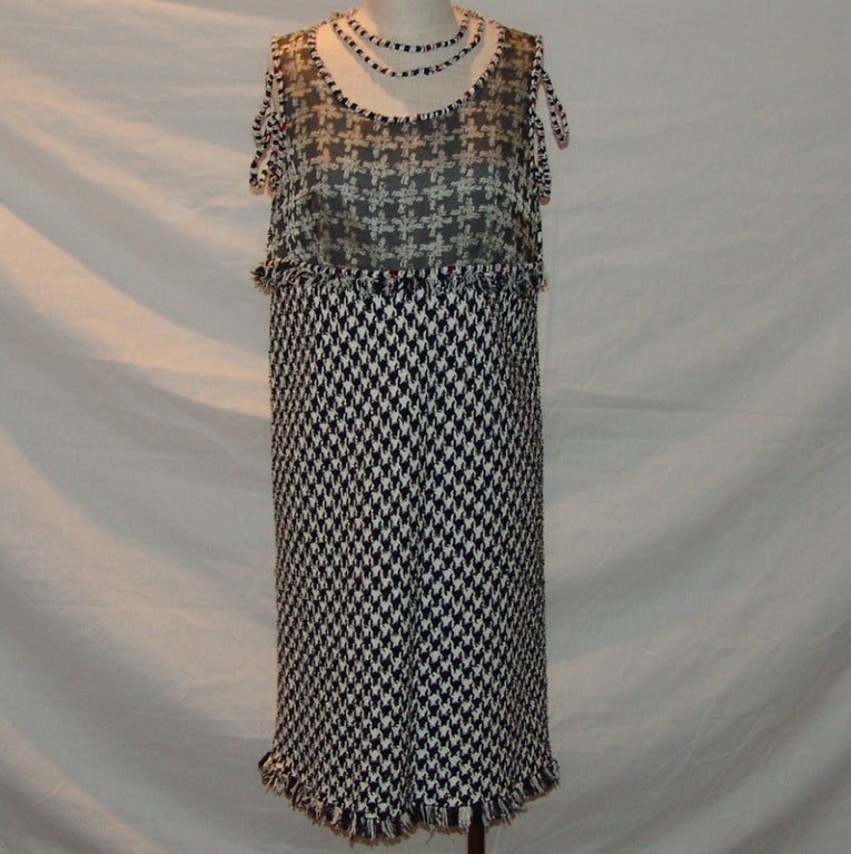 Chanel Black & White with Red Detail Houndstooth Dress - 44. This dress is in excellent condition and is new with tags. It comes with the extra swash of fabric. The dress has loops that go around your neck and look like a necklace and also has loops