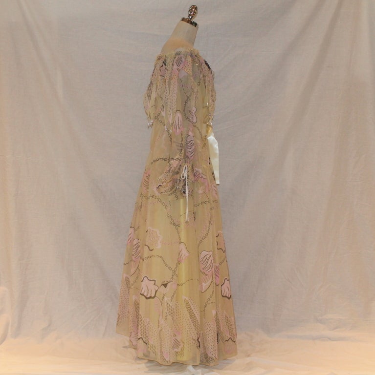 Zanda Rhodes Pale Yellow Silk Organza Print Gown - L - Circa 80's. W/ Petticoat and beads/pearl details throughout. Truly a dream dress. This dress is in excellent vintage condition.

Measurements:
Expandable 36' waist to 60
Sleeve length 22