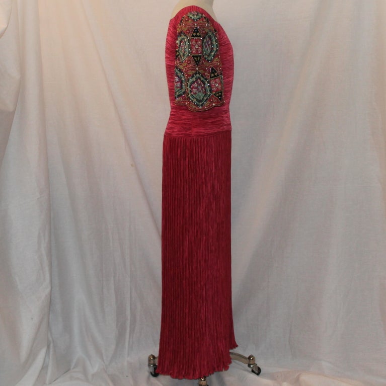 Mary Mcfadden Raspberry Gown with Heavily beaded sleeve-Sz 12 Circa 80's,Gown is in excellent pre-owned condition. Measurements:
Bust 38
Hips 40
Sleeve length 14
Length 53