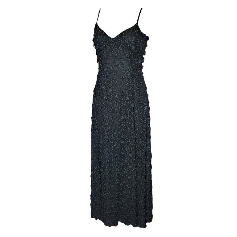 Escada Couture 1990’s Black Embroidered Applique Gown-Size 36. The simple yet elegant fully lined gown has spaghetti straps and a v shaped neckline, is fitted in the bodice and then slightly flares our to a semi wide skirt at the bottom, has