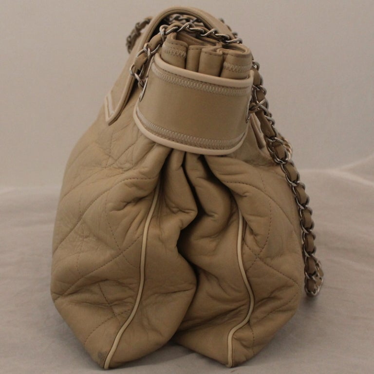 Chanel Tan Lambskin Shoulder Handbag - SHW This bag has 3 main inside compartments, also a zip inside pocket on one side and a cell phone and other pocket in the other compartment.  Comes with duster.
Measurements are as follows:
Length