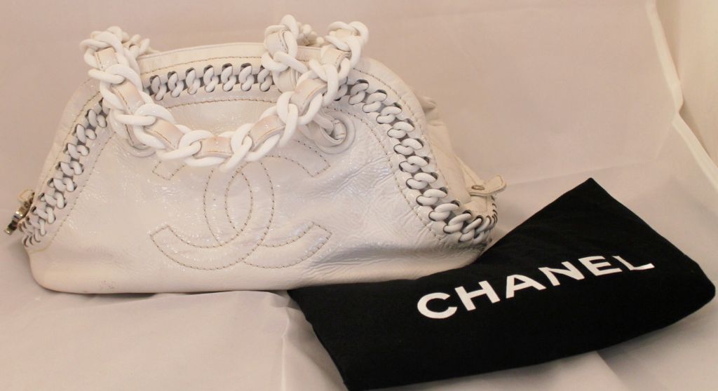 Chanel White patent leather bowler bag with resin chain strap. This bag is in good pre-owned condition.