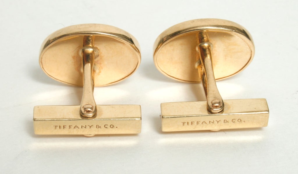 This handsome pair of Tiffany cuff links have oval Carnelians mounted in substantial gold bezels. They are 14kt gold with a swivel bar. A way to add a little color to a traditional man.