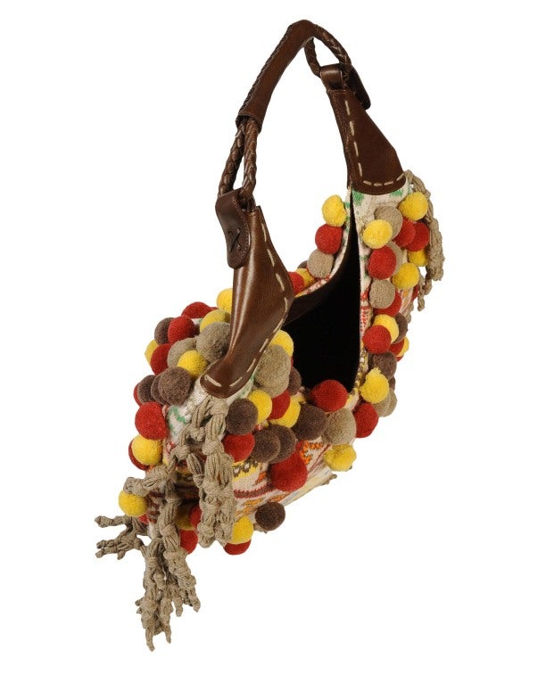 Highly collectible handbag. Designed by Alexander Mcqueen himself. 

2005 Fall/Winter collection

Made of multi-colored Navajo style knit and finished with pompoms and tassel trim, this bag will definitely bring the attention. Inside it is lined