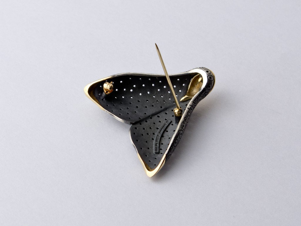 Pedro Boregaards Empress Moth Pin here in 14K yellow gold and Sterling Silver is part of his legendary moth collection. 
It is abstract in design and shows no eyes or legs yet is immediately recognizable as moth.
The golden head and wingtips are