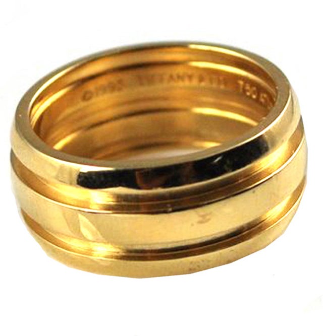 An older wide gold band from the 'ATLAS'  collection.  This is circa 1995.  Made of 18Karat yellow gold and in pristine condition. It is a size 6 1/2 and is  8.9MM wide and weighs a substantial 9.9 grams. It has a very contemporary linear look.