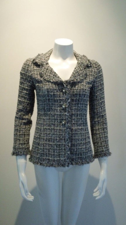 This great easy to wear black-white and grey jacket goes nicely with a skirt, jeans or any pair of black slacks. The traditional Chanel fringe accents the jacket coupled with<br />
the pearl buttons and gun-metal trim makes it easy to accessorize