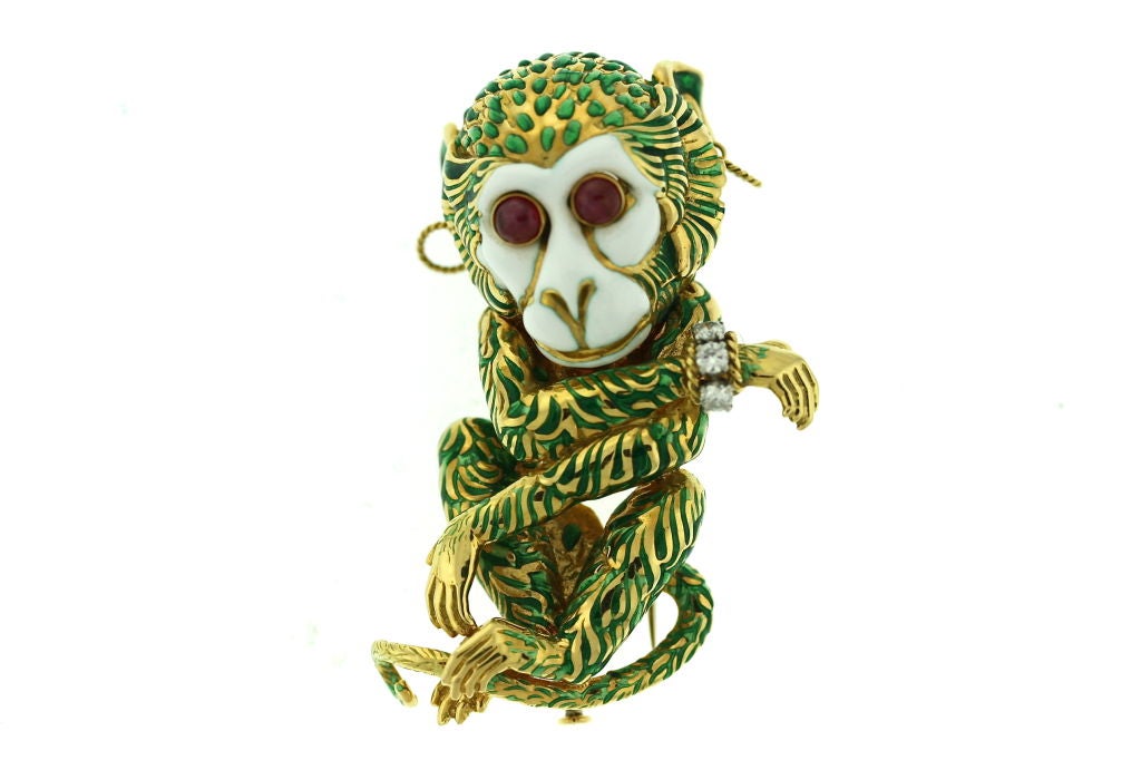 A clever and beguiling 18k gold monkey brooch clip by David Webb. This monkey's got it all...cabochon ruby eyes, diamond bracelet, twisted gold wire earrings and a knowing smile. A wonderful conversation piece and whimsical piece of jewelry. Signed
