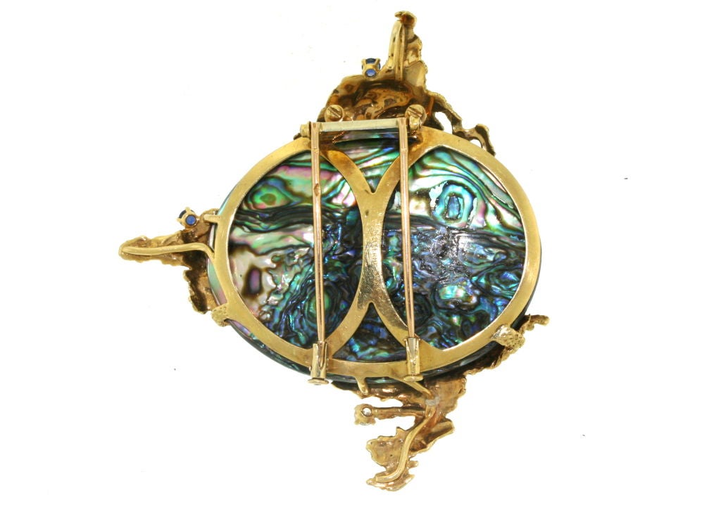 A most interesting brooch clip with a concealed pendant loop by Mellerio dits Meller designed as a center oval shaped abalone shell with 18k textured gold abstract elements to the top, bottom and right set with three full cut diamonds of various