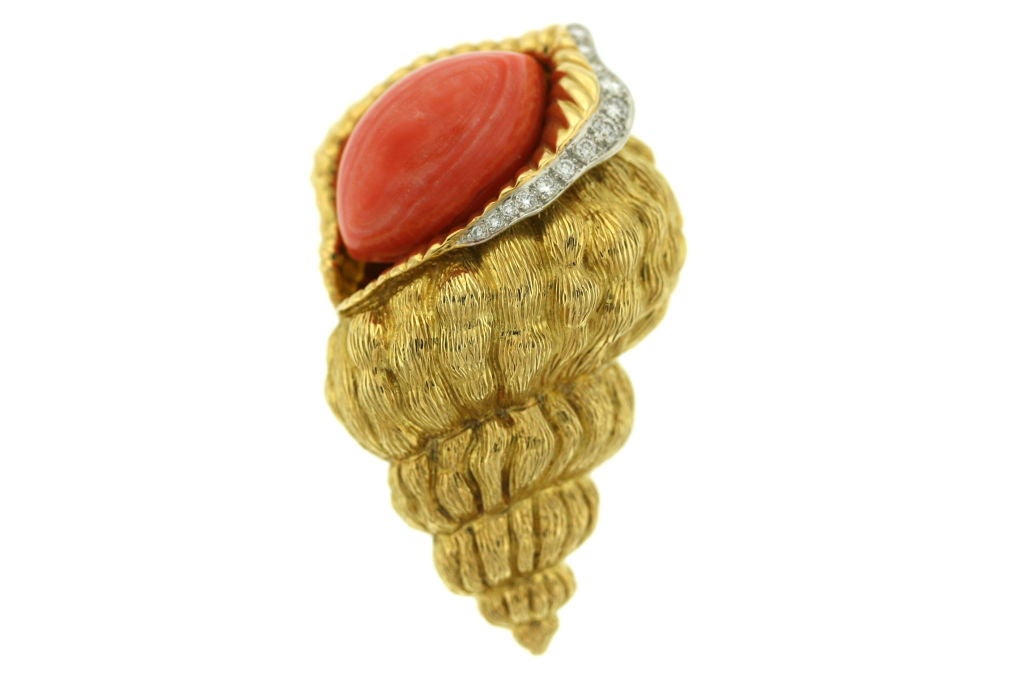 An 18k textured gold and platinum brooch clip of a shell motif with a marquis-shaped center piece of coral with thirteen diamonds along the cusp of the shell. A very elegant and versatile piece of jewelry. Signed DAVID WEBB 18k 900 PT