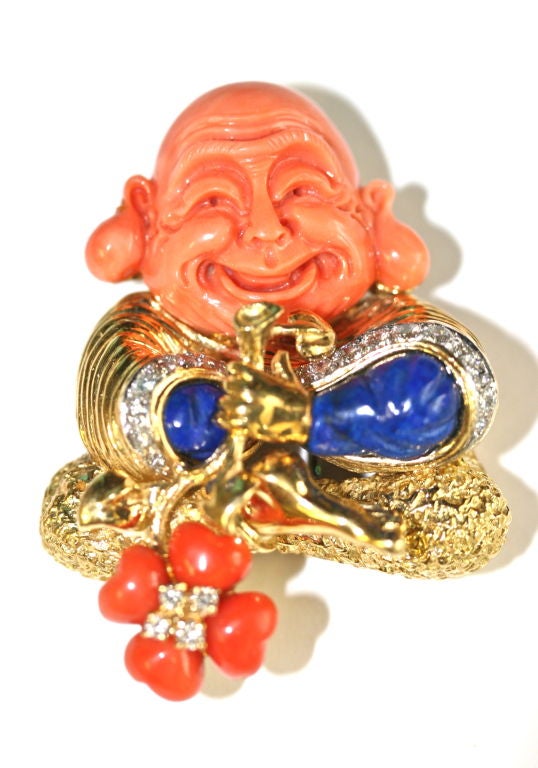 Tiffany & Co 18k gold brooch clip of a Buddha motif in beautifully carved coral and lapis with diamonds. This whimsical piece was likely designed by Donald Claflin who created extraordinary jewelry for Tiffany in the late 1960s through early 1970s