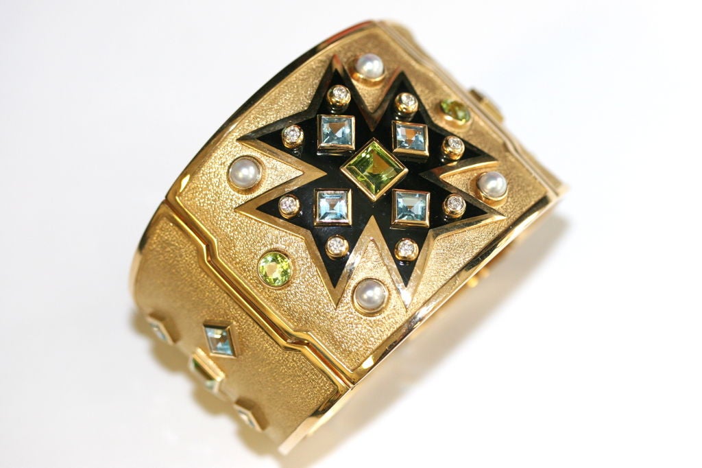 Iconic Verdura 18k hammered gold hinged cuff bracelet of a maltese cross motif in black enamel with aquamarine, peridot and pearls. Signed Verdura. Internal circumference measures 6.75