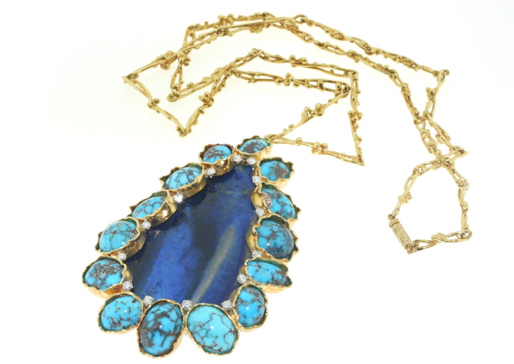 Wonderfully executed 18k textured gold necklace of a very artistic and organic design featuring a large pendant of lapis surrounded by beautifully veined turquoise stones and accented with diamonds set in platinum on a matching 18k gold neck chain.