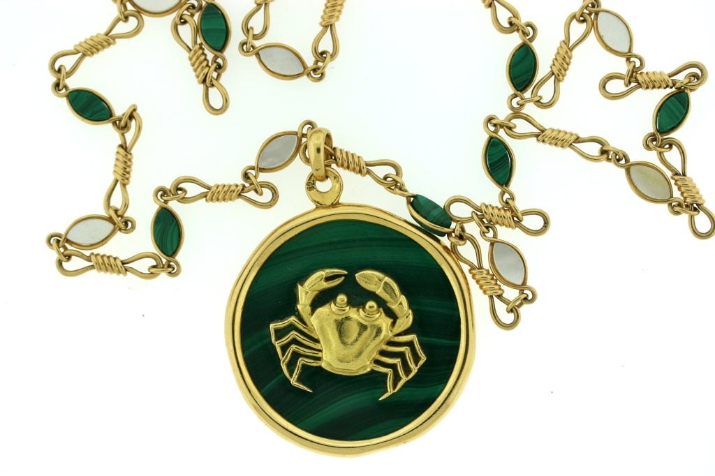 A beautiful and very unusual long necklace by Van Cleef and Arpels designed as a malachite pendant framed in 18k gold and centered with a gold crab motif suspended from a matching 18k gold chain with alternating links set with malachite and