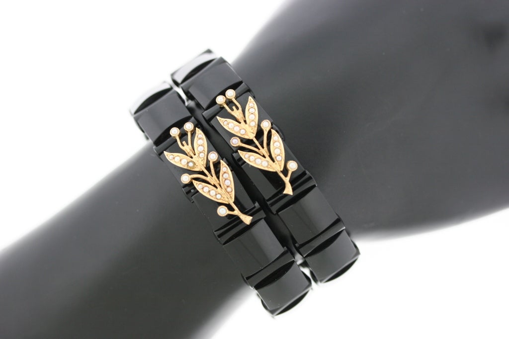 A stunning pair of black onyx hinged bangle bracelets of alternating square and tubular links with delicate gold and pearl foliate motifs. These bracelets look very elegant and fine when worn alone and more bohemian and casual when mixed with other