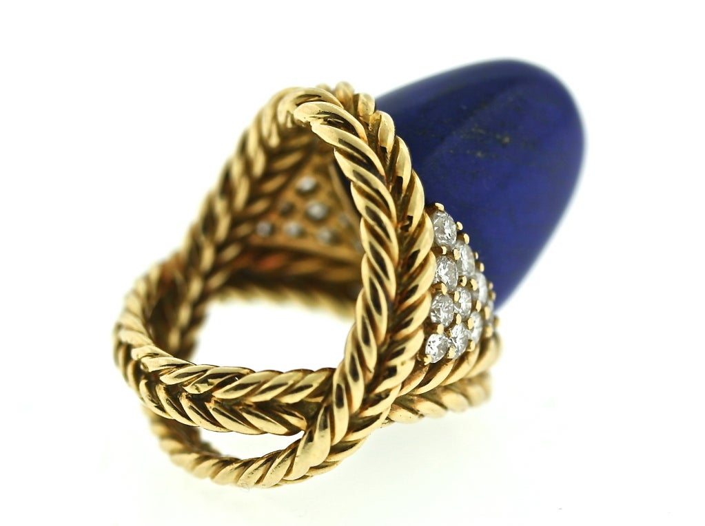 A spectacularly stylish Boucheron Paris 18k twisted gold work ring of a criss crossed shank design centering a vivid lapis stone flanked by 20 diamonds totaling one carat. This is a statement ring that is beautifully executed and has a wonderfully