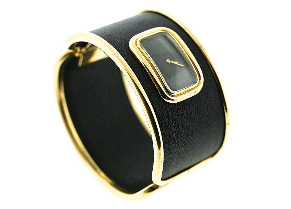 A French 18k yellow gold watch set into an 18k yellow gold English hinged cuff bracelet covered with a rich chocolate brown leather. This is a very chic and modern piece and unlike any I have seen before. It is the true marriage of a fashionably
