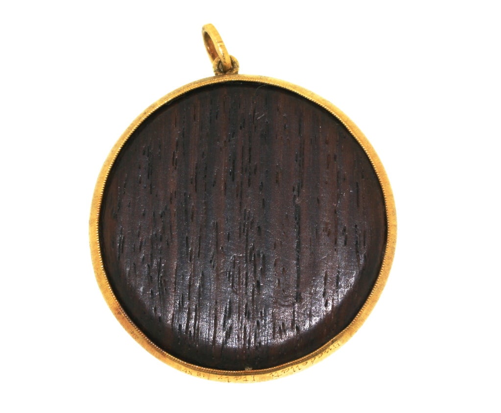 Buccellati dark wood pendant (possibly mahogany) bordered by hand-finished 18k brushed gold and centering a beautiful stylized sunburst design with very fine hand-finished engraving. It is uncommon to find Buccellati pieces made with wood. In the