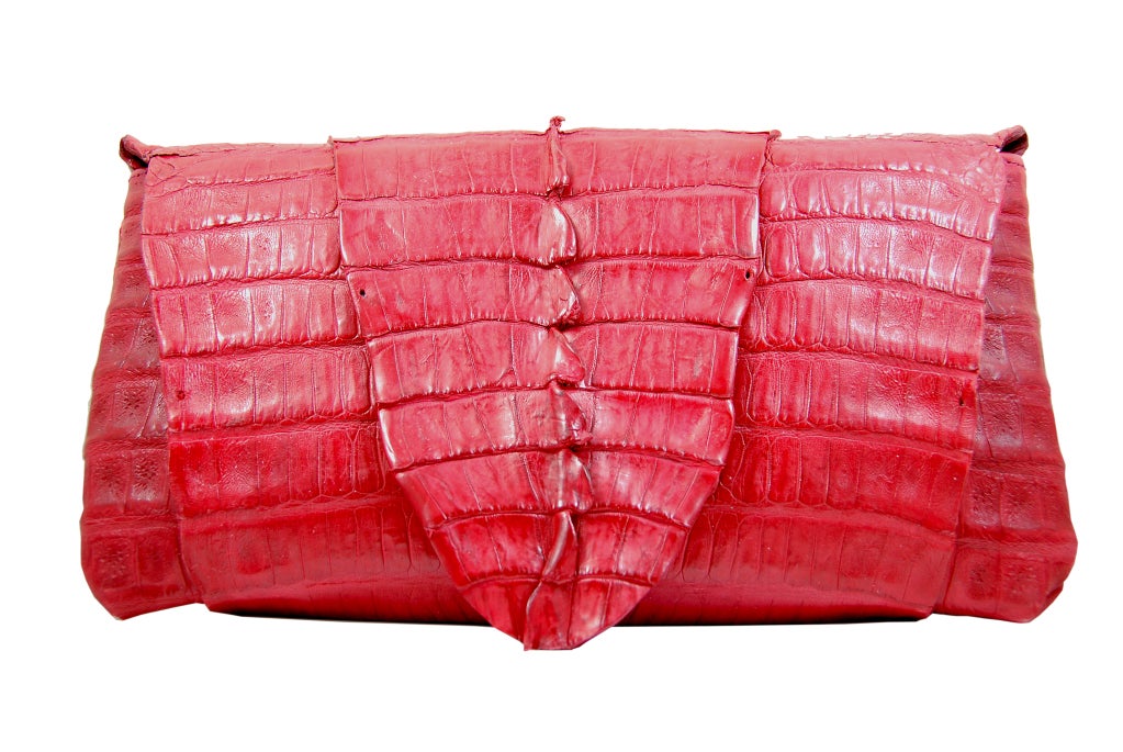 This is a gorgeous wrap crocodile clutch by B. Romanek. The skins area rich, true red color.  The full skin wraps around the bag to create the closure. Measures 10