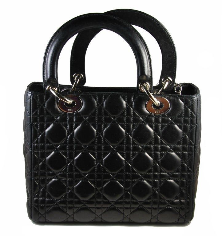 Gorgeous Christian Dior Lady Di (Dior) bag in black Cannage quilted leather. Red interior with one zippered compartment and silver hardware, including DIOR attached charms. Comes with its dust bag. Measures 10
